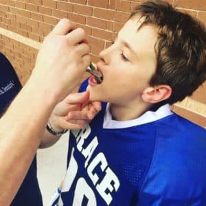 Houston Orthodontist Reparing Braces at Kids Football Game